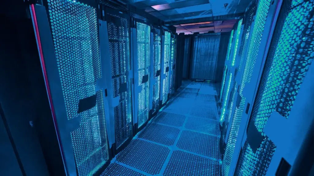 An aisle of illuminated server racks in a data centre